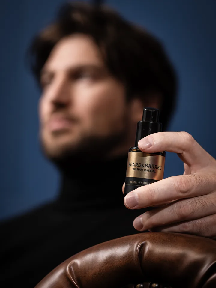 A man holding the Beard & Barrel bottle