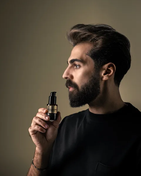 A man in profile holding the Beard & Barrel bottle