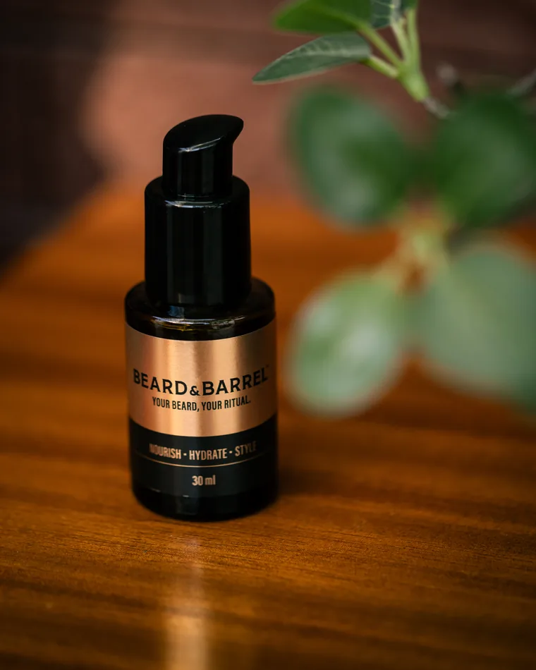 The Beard & Barrel bottle on a wooden surface beside a green plant