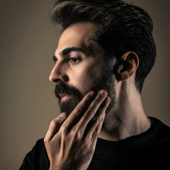 Massaging the oil through the beard from roots to tips